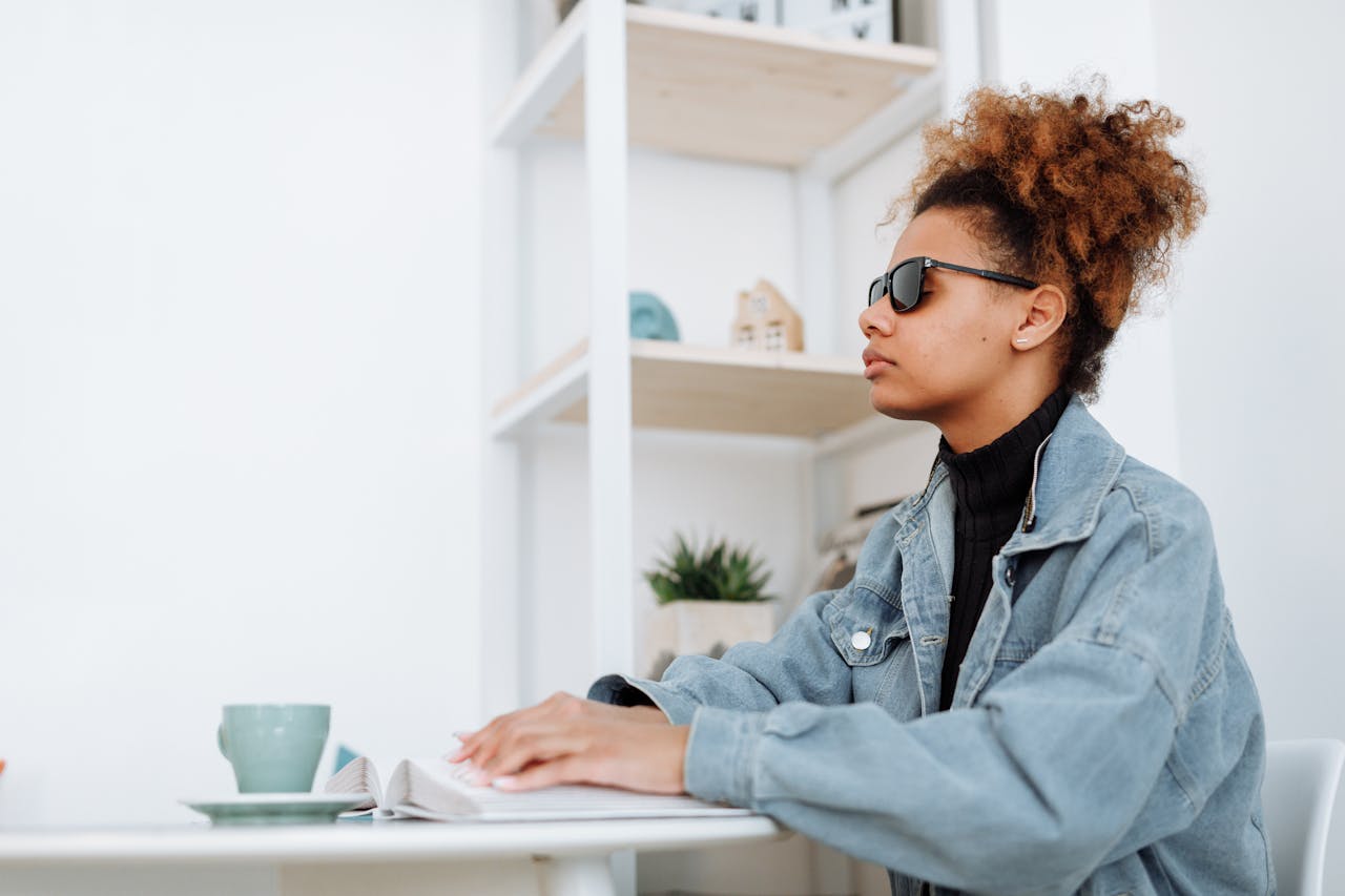 Woman in Denim Jacket Reading Braille